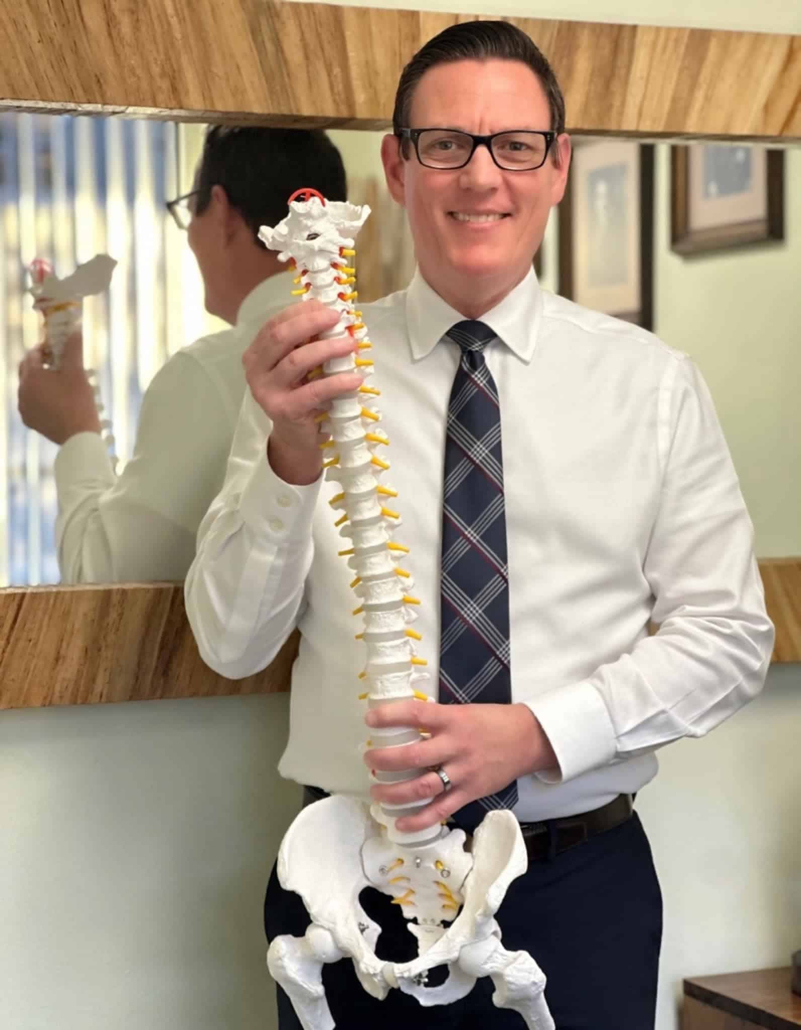 Dr. Roger Smith demonstrating spinal anatomy with an anatomical model